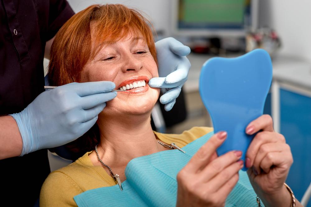 woman smiling with mirror | dental bonding brooklyn