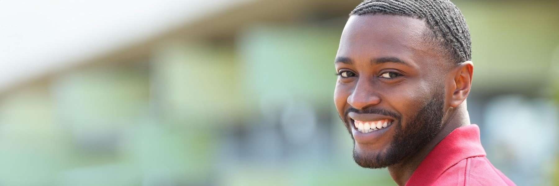 A smiling man looking back