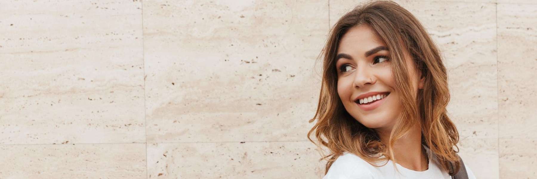 woman with brown hair smiling | dental crowns dumbo