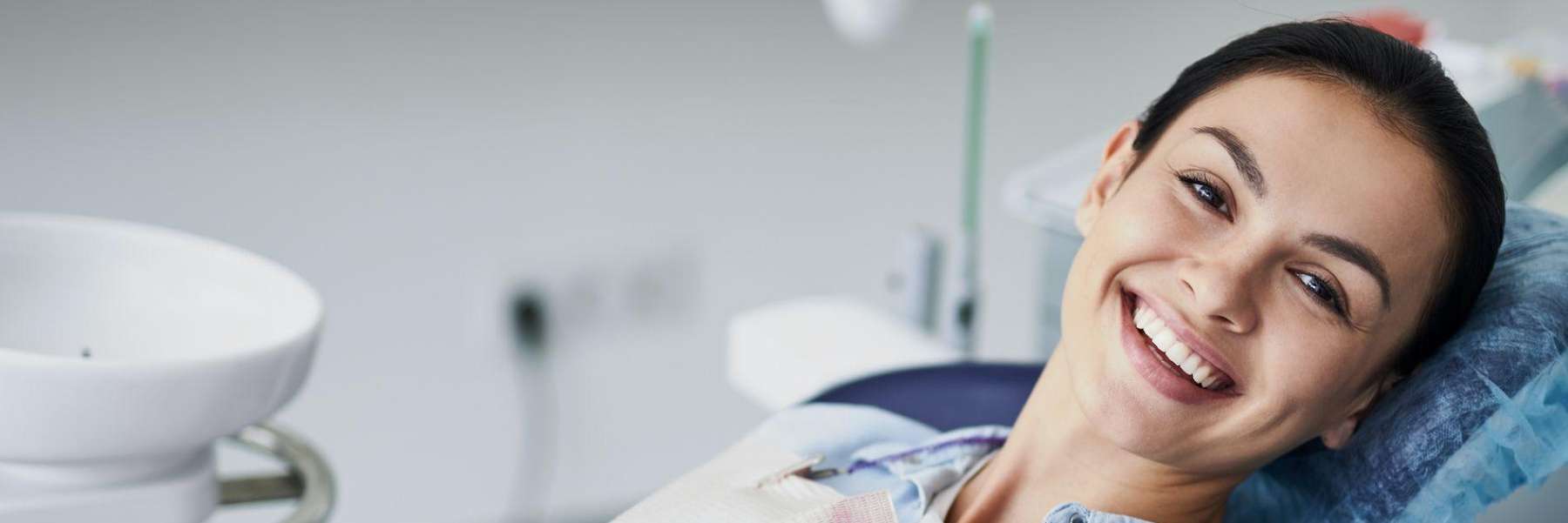 A smiling woman getting a dental exam in Brooklyn