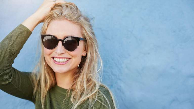 woman in black glasses smiling | invisalign 11201