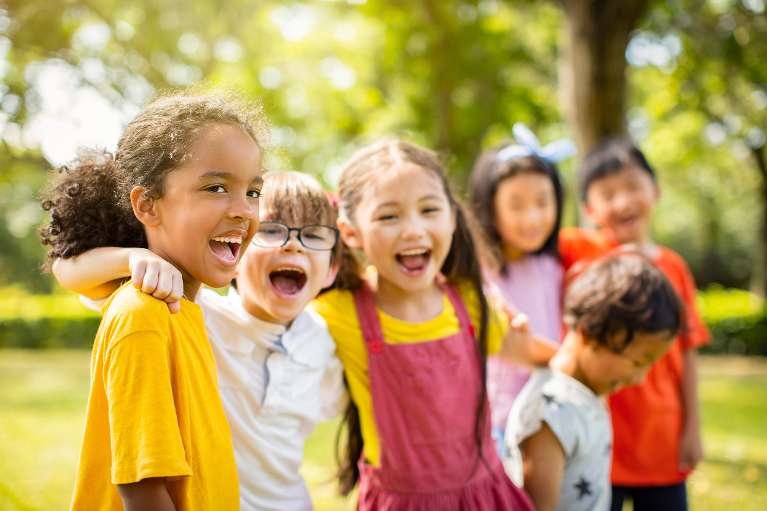 A group of children laughing in a field