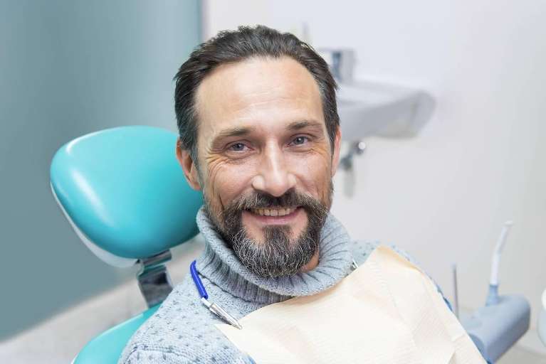 A man smiling before a dental exam