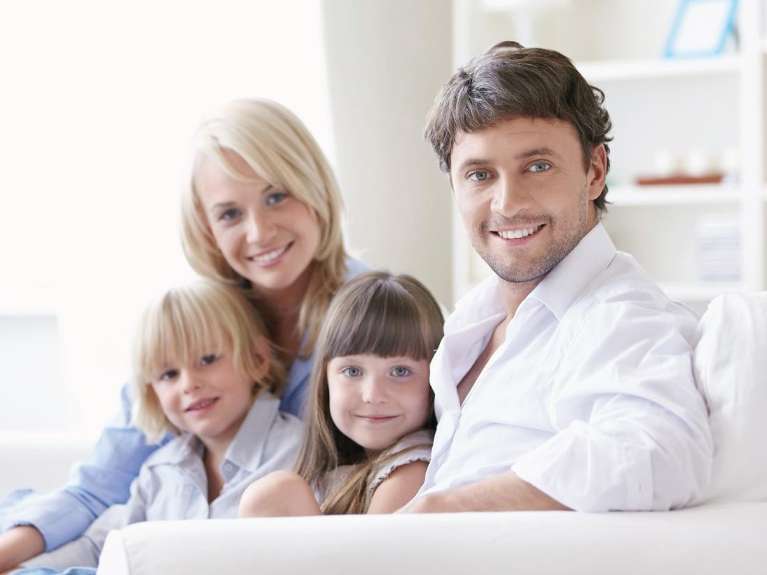 family of four sitting on couch | best dentist dumbo ny