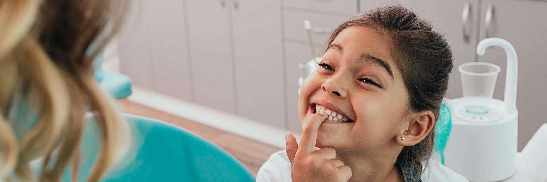 young child showing missing tooth | pediatric dentist dumbo heights