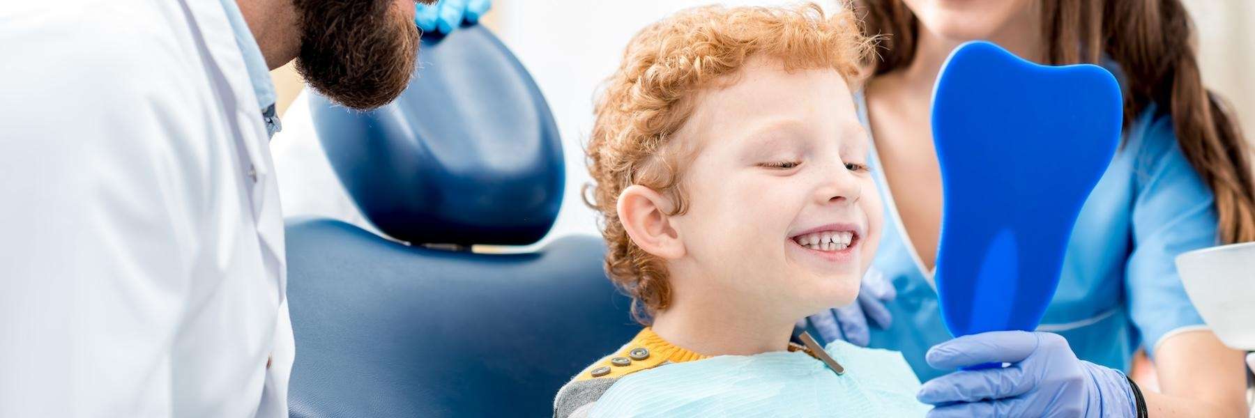 child smiling at mirror | pediatric dentistry dumbo